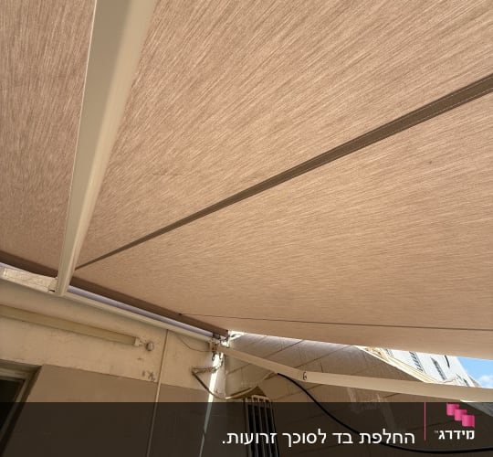סוכך בד מותקן על קיר חיצוני